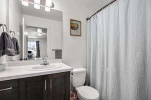 Bathroom featuring a shower with shower curtain and vanity