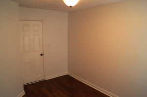 Spare room with baseboards and dark wood finished floors