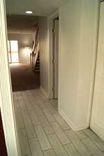 Corridor with stairs, recessed lighting, and wood finish floors