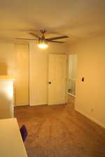 Unfurnished room with light colored carpet and ceiling fan
