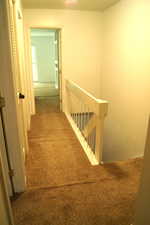 Hall with an upstairs landing and carpet