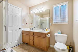 Full bathroom featuring double vanity, light tile patterned flooring, and a stall shower