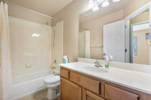 Full bath with shower / bath combo with shower curtain, vanity, and light tile patterned floors