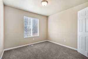 Carpeted empty room with baseboards