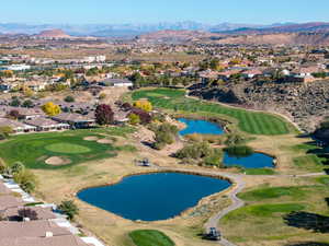 Aerial view of property and surrounding area featuring nearby suburban area and a water and mountain view