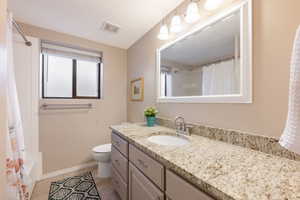 Bathroom with vanity, shower / bath combo, and light tile patterned floors