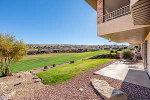 View of grassy yard with a patio area and a residential view
