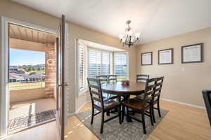 Dining area featuring light wood-style floors, a chandelier, and a textured ceiling
