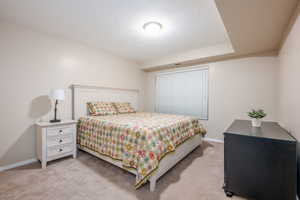 Bedroom featuring light carpet and a textured ceiling