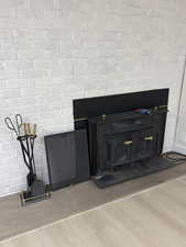 Detailed view of brick fireplace and wood burning stove with stunning light wood laminated finished floors