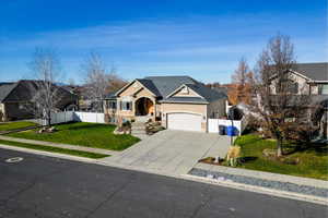 Traditional-style house featuring concrete driveway, a garage, stucco siding, and a shingled roof