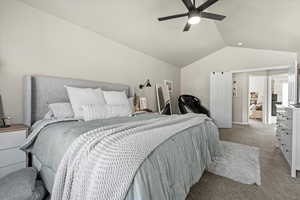 Bedroom featuring vaulted ceiling, carpet floors, and ceiling fan