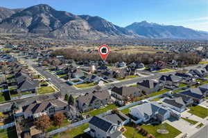 Aerial view of property and surrounding area with a mountain backdrop and nearby suburban area