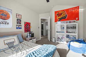 Bedroom with lofted ceiling, carpet flooring, and ceiling fan