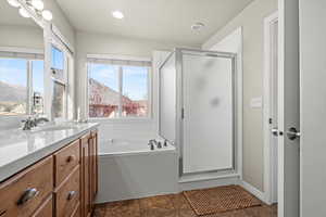 Full bathroom with a garden tub, vanity, a stall shower, a mountain view, and recessed lighting
