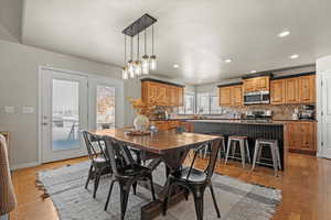 Dining room with light wood finished floors and recessed lighting