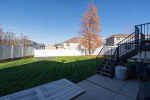 Fenced backyard with stairway, a patio, a residential view, and a deck
