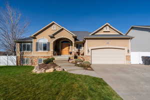 View of front of property with stone siding, stucco siding, concrete driveway, and stairs