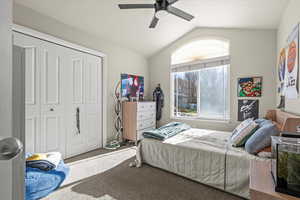 Bedroom featuring vaulted ceiling, carpet flooring, a closet, and ceiling fan