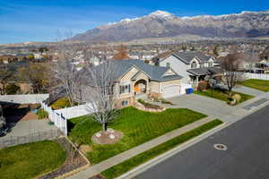 Traditional home featuring a residential view, a mountain view, concrete driveway, a garage, and stone siding