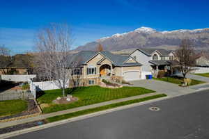 Single story home with a mountain view, concrete driveway, and an attached garage