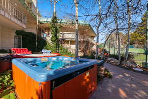 Wooden terrace with a hot tub and a patio area