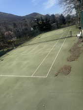 View of tennis court with a mountain view