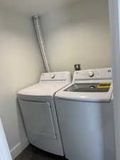 Washroom featuring washer and dryer and baseboards
