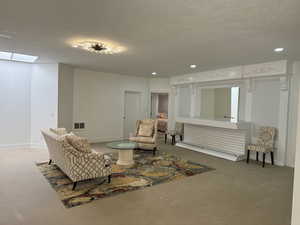 Living area with concrete floors, a textured ceiling, and a skylight