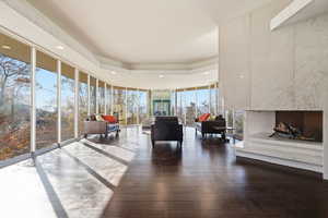 Living room featuring expansive windows, a tray ceiling, dark wood-style floors, and recessed lighting