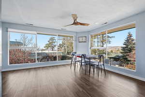 Dining space featuring wood finished floors, ceiling fan, healthy amount of natural light, and a textured ceiling