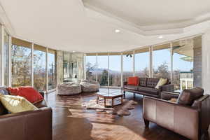 Sunroom featuring a wall of windows, recessed lighting, plenty of natural light, and wood-type flooring