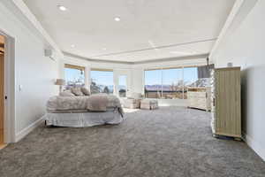 Carpeted bedroom with a wall mounted AC and recessed lighting