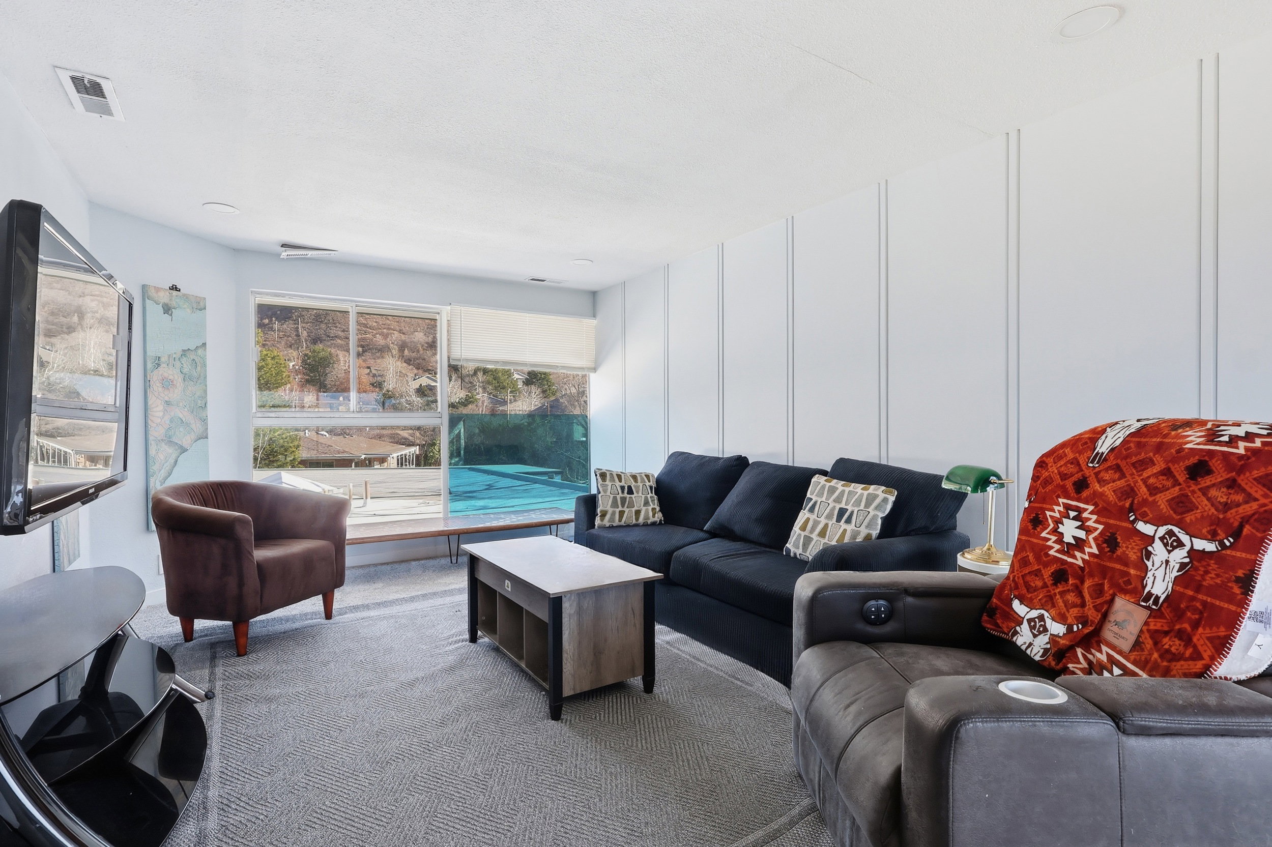 Carpeted living room with a decorative wall
