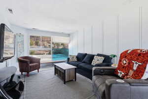 Carpeted living room with a decorative wall