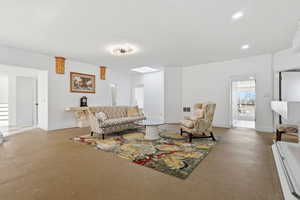 Living room featuring finished concrete flooring and recessed lighting