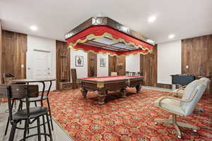 Game room with wooden walls and billiards table