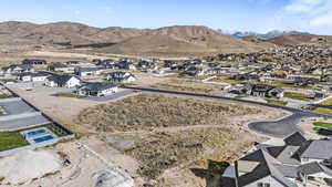Aerial view of property and surrounding area with nearby suburban area and a mountainous background
