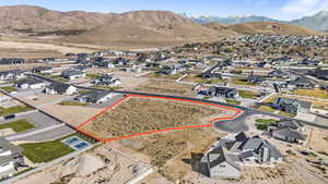 Aerial perspective of suburban area with property boundaries highlighted and a mountain backdrop