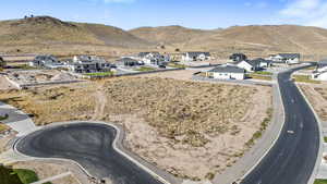 Aerial view of property and surrounding area featuring a mountainous background and nearby suburban area