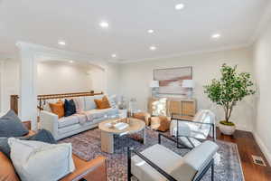 Living room featuring ornamental molding, recessed lighting, and dark wood-type flooring