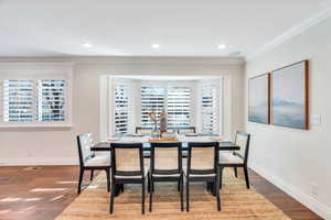 Dining space with ornamental molding, dark wood finished floors, and recessed lighting