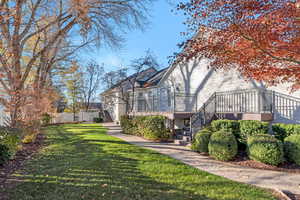Rear view of house with stairway and a wooden deck