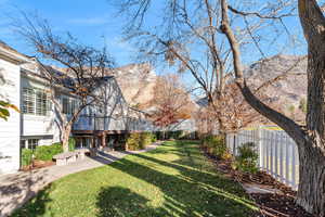 Fenced backyard with a deck with mountain view