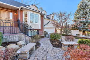 View of front of house featuring brick siding, roof with shingles, and a gate