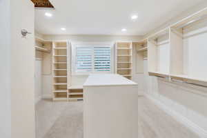 Spacious closet with light carpet