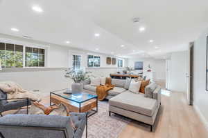 Living room with light wood-style floors and recessed lighting