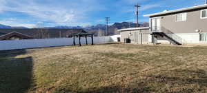 Fenced backyard featuring a gazebo, a mountain view, a patio area, and stairway