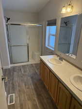 On suite bathroom with two sinks, step in shower.