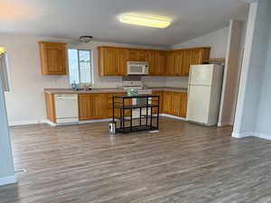 Spacious kitchen featuring white appliances, wood cabinets, and light counter tops, complete with a movable island.